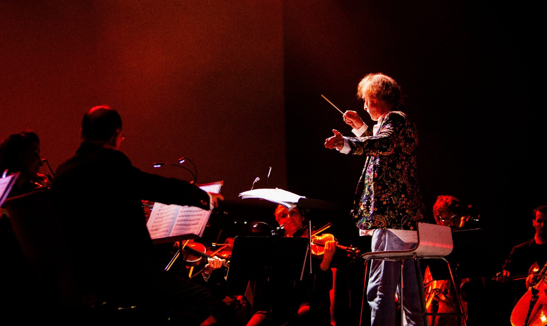 Friedemann Riehle conducting the strings in red light