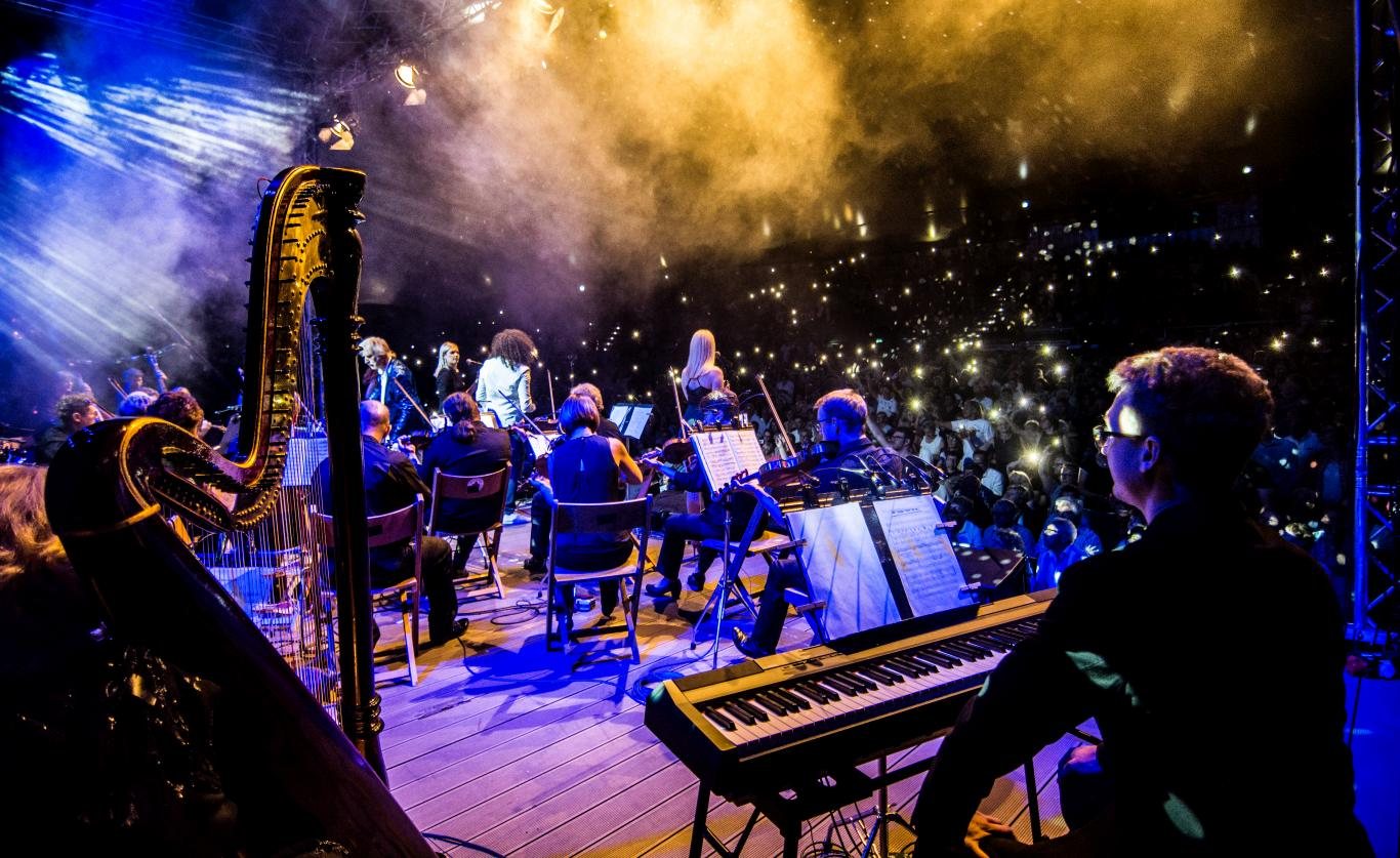 Orchestra and harp under blue and gold light