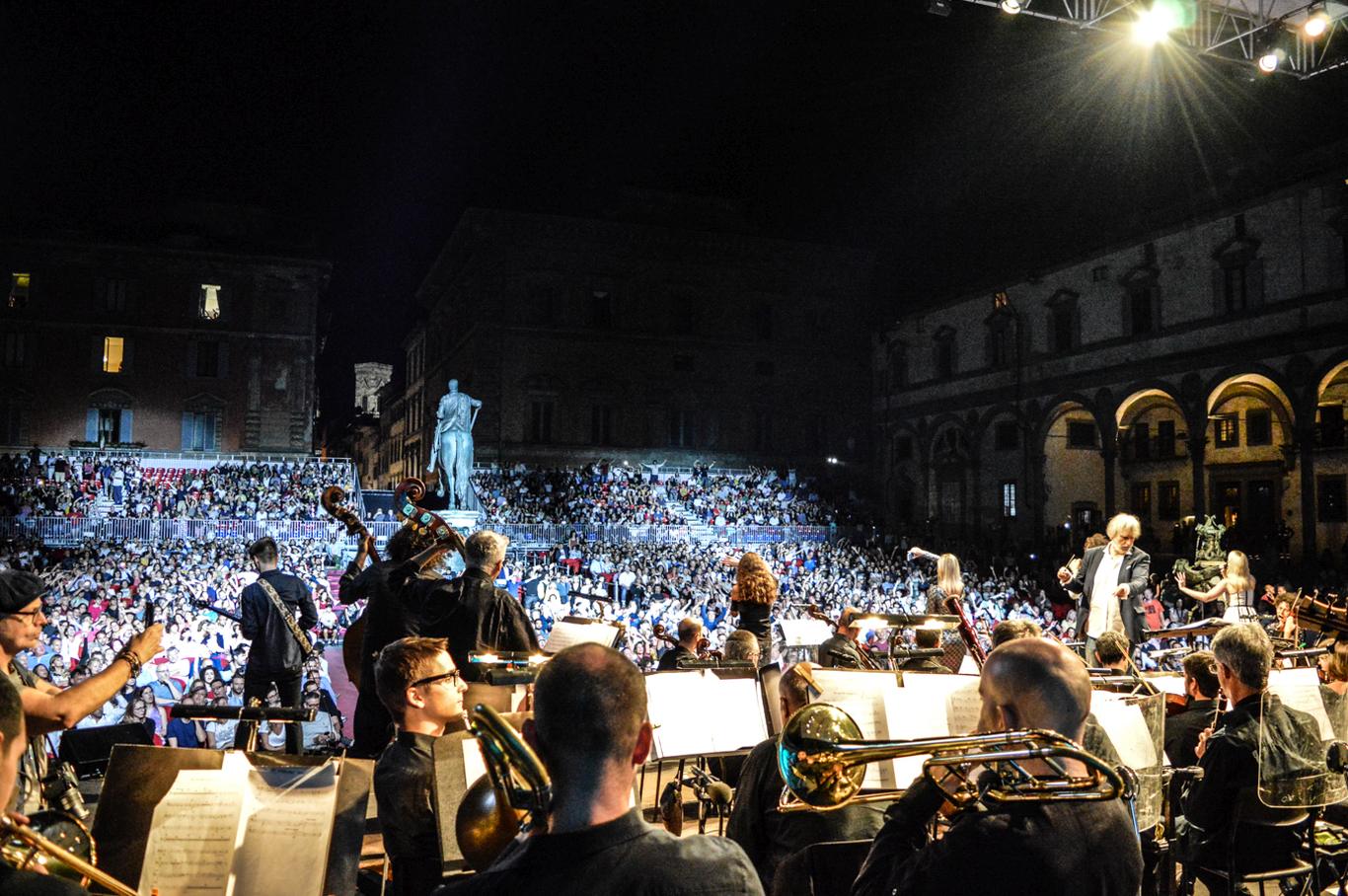 Open-air concert with the orchestra in front of a full square